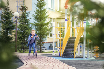 boy moving on scooter on the children playground
