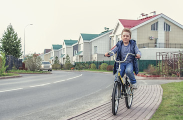 boy on bike  riding  along the street