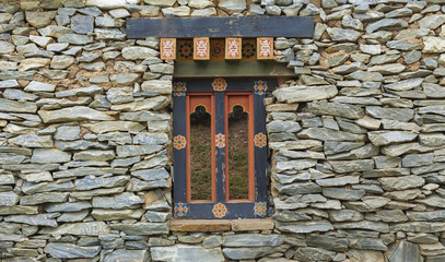 Stone wall with old wooden window design 