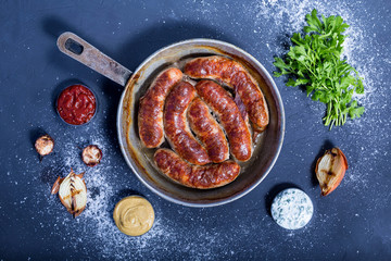 Country style oven-baked sausages in a frying pan,  sauce