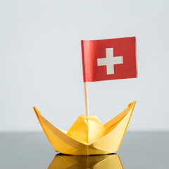 Papierschiff mit schweizer Flagge