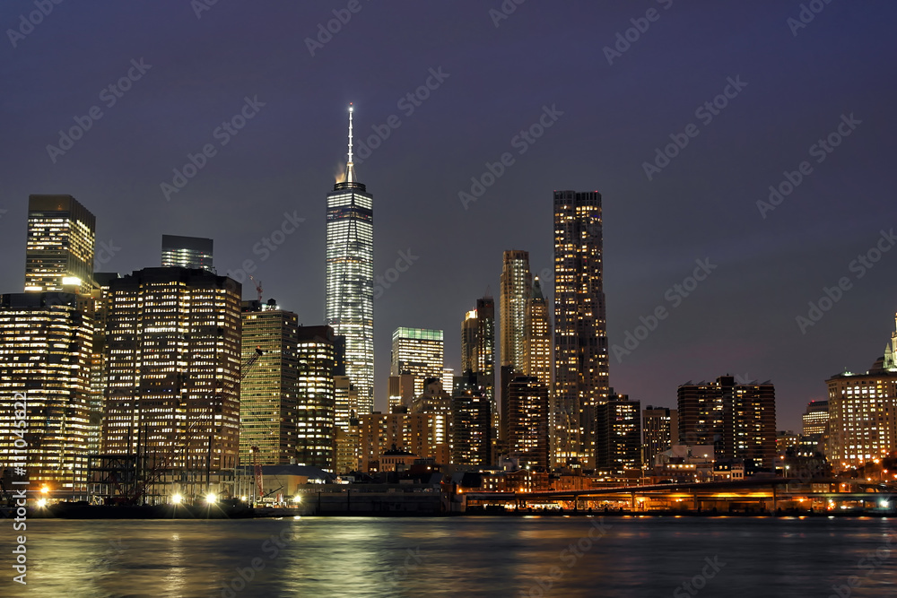 Wall mural downtown manhattan at night with the new world trade center and east river