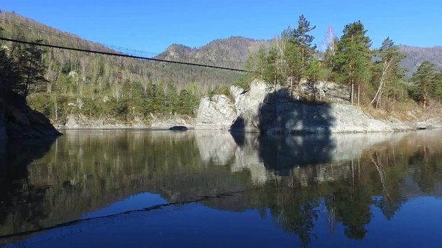 Hinged bridge to the monastery on Patmos island on river Katun in Chemal, Altai, Siberia, Russia