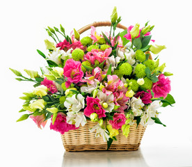 Beautiful bouquet of bright flowers in basket . Isolated on whit