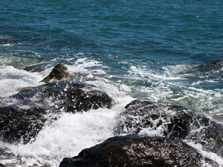 Sea wave crashing on rocks on the beach