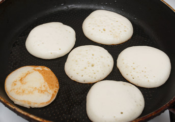 pancakes are fried in a pan