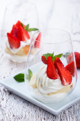 Homemade sponge layer cake with  strawberries in a glass