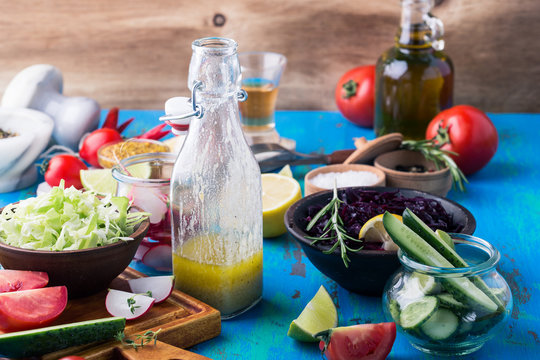 Vinaigrette And Ingredients. Organic Vegetables On Rustic Table