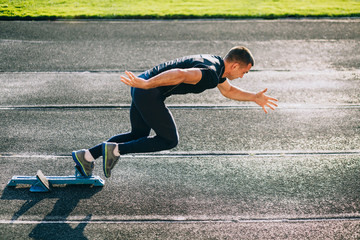 Sprinter leaving starting blocks on the running track