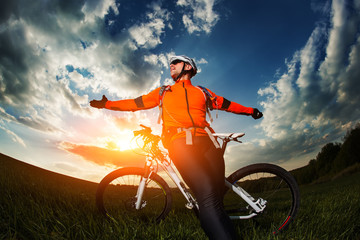 wide angle portrait against blue sky of mountain biker Cyclist
