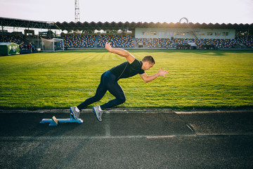 Sprinter leaving starting blocks on the running track