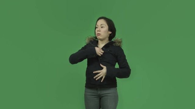 caucasian girl with winter jacket isolated on green screen warm undressing