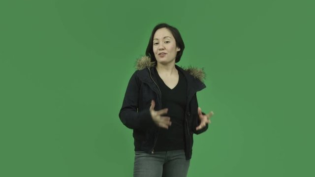 caucasian girl with winter jacket isolated on green screen talking interview