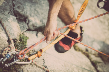 Climber securing a rope on a stone wall