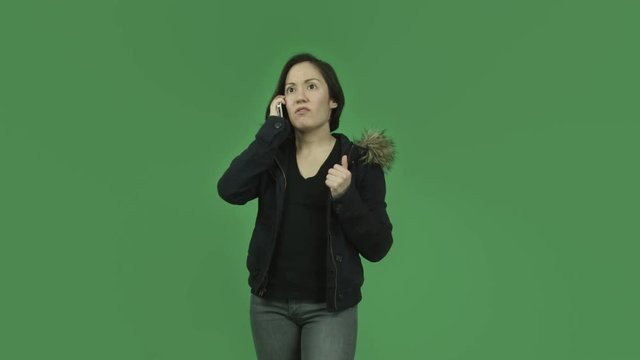 caucasian girl with winter jacket isolated on green screen talking cell phone