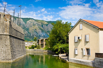 Fototapeta na wymiar House with tile roof, canal and fortress wall in the city of Kotor, in Montenegro