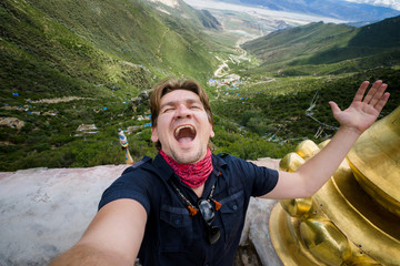 Happy young male's crying at the top of Chimpu caves in Tibet, China