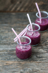 Blueberry smoothie in small glasses on a wooden table