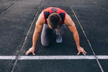 Sprinter leaving starting blocks on the running track. Explosive start.