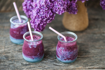 Blueberry smoothie in small glasses on a wooden  table