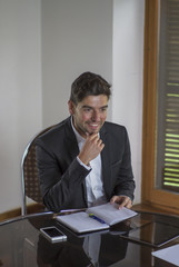 Fototapeta premium Young worker man smiling and touching his chin during a business meeting