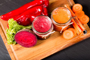 Fresh beetroot and carrot smoothie in the glass on black stone. Lifestyle concept