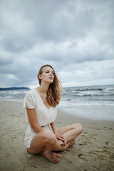young beautiful woman on cold windy beach