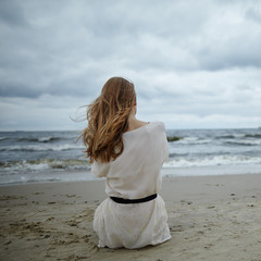 young beautiful woman on cold windy beach