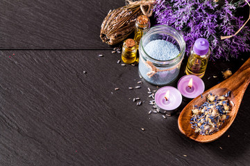 spa massage setting, lavender product, oil on black stone background