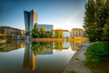 Vienna cityscape with modern Uniqa Tower on the water channel in the morning. Long exposure image...