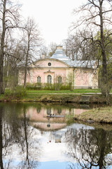 Pink house in the style of Russian classicism at the lake a cloudy spring day.