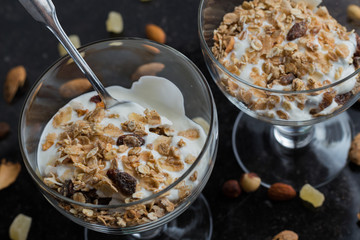lass bowl on dark background. Delicious, healthy sweet dessert for breakfast. Cereal, muesli.  Copy space, closeup.