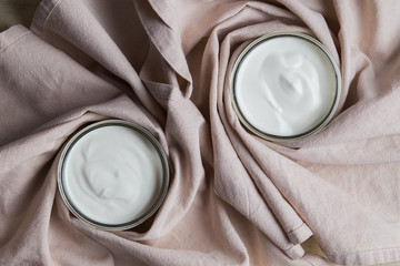 Yogurts assortment  in ceramic bowls on wooden light background. Natural and fruit  healthy, diet, gourmet dessert for granola breakfast. Sweet yoghurts closeup.