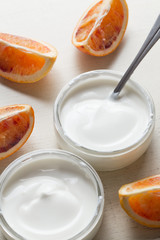 Yogurts assortment  in glass bowls on wooden light background. Natural and fruit  healthy, diet, gourmet dessert for granola breakfast. Sweet yoghurts closeup.