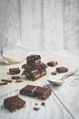 chocolate stack, chips and seeds of sesame on a wooden table
