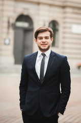 Fototapeta premium Handsome stylish young businessman posing portrait outdoor