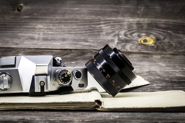  old camera at  vintage book, wooden background