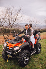 Fototapeta na wymiar Man and woman having fun on an off road adventure. Couple riding on a quad bike in countryside on a summer day.