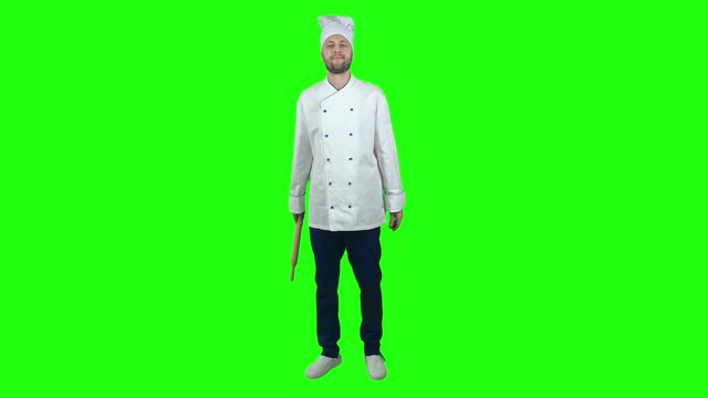 Professional baker standing on chroma key background and holding rolling pin