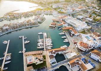 Fototapeta na wymiar Aerial view of the beautiful Marina in Limassol city in Cyprus,beach,boats,piers,villas and commercial area.A modern,high end,newly developed space with docked yachts and for a waterfront promenade.