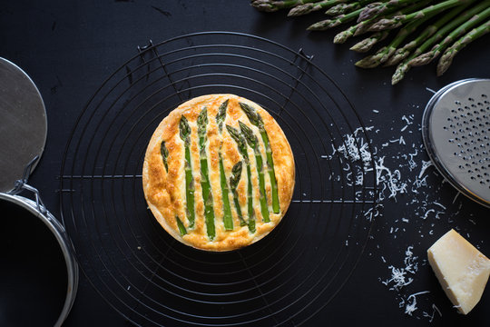 Asparagus tart with egg and cheese filling on the cooling rack. Selective focus.