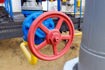 Fototapeta na wymiar Red faucet with steel pipe in natural gas compressor station in summer day