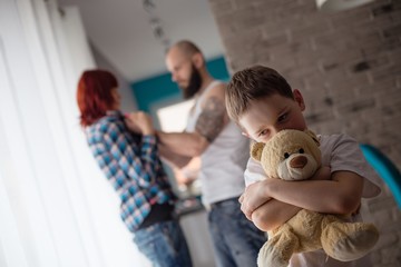 Sad, desperate little boy during parents quarrel