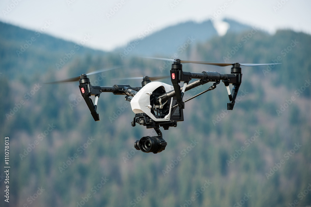 Wall mural drone with high resolution digital camera/white drone with digital camera flying in sky over mountai
