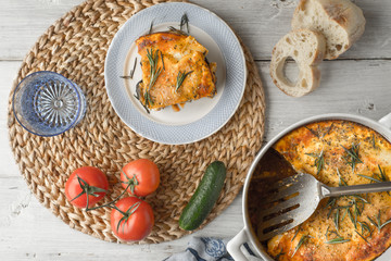 Eating moussaka in the white table with tableware and vegetables