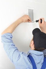 Handwerker öffnet Luftschacht zum Filterwechsel.jpg