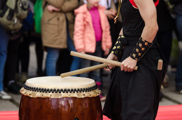 Fototapeta na wymiar Japanese artist playing on traditional taiko drums