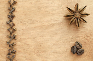 Cloves, star anise, coffee beans on a wooden table.