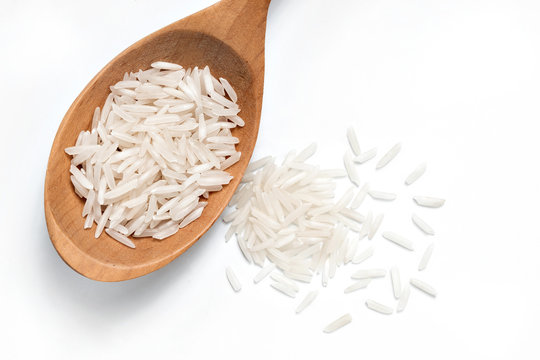 White Rice on a wooden spoon on white background. Close up, top view, high resolution product.