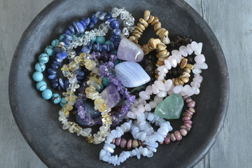 Healing properties of gemstones and crystals on a pottery bowl with wooden background